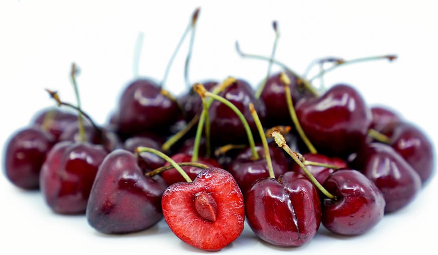 Cherry 'Lapins/Dawson' fruit: a pile of glossy dark red sweet cherries with green stalks, one halved to show the stone.
