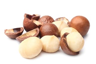 Macadamia 'GT205' nuts, showing whole round brown shells, cracked shell halves and creamy-white kernels grouped together on a white background.