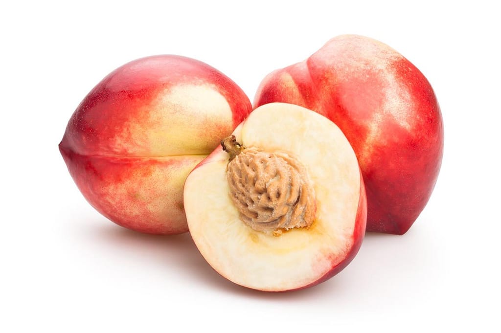 Nectarine 'Queen Giant' fruit, two whole with crimson-red and cream skin and one halved to show pale flesh and stone, on white.