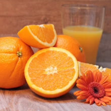 Fresh Citrus orange 'Newhall', sliced and whole, with a glass of juice and orange flower. Bright, juicy, and ready to enjoy.