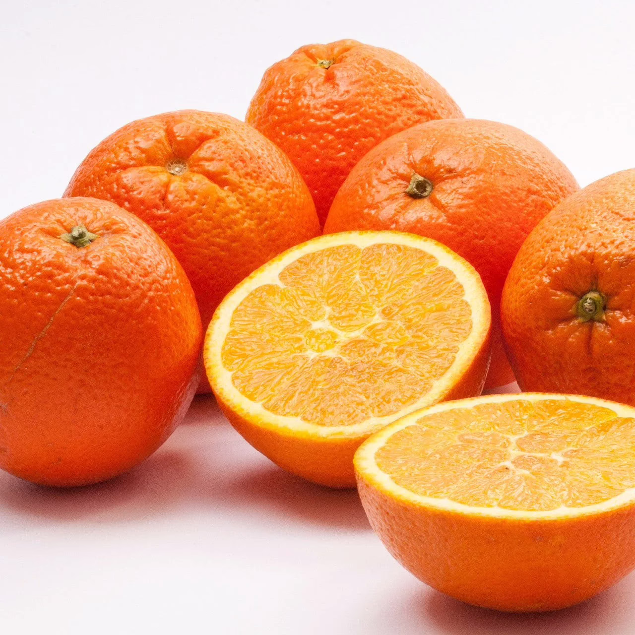 Citrus orange 'Newhall': Several bright orange Newhall oranges, one cut in half, showcasing juicy segments