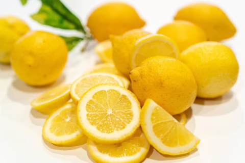 Fresh Citrus lemon ‘Meyer’ display: Whole and sliced, showcasing juicy yellow pulp and zest