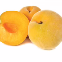 Three ripe yellow plums, one sliced in half revealing its orange pit, sit against a white background. The plums have a slightly fuzzy skin, typical of the fruit.