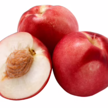 Three ripe, red nectarines, one sliced open to reveal its white flesh and seed. Fresh and juicy summer fruit.