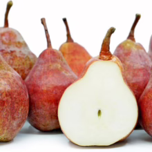 Red Bartlett/Conference pears: a group of ripe, red-blushed pears, one cut open to reveal its white flesh and small seeds.